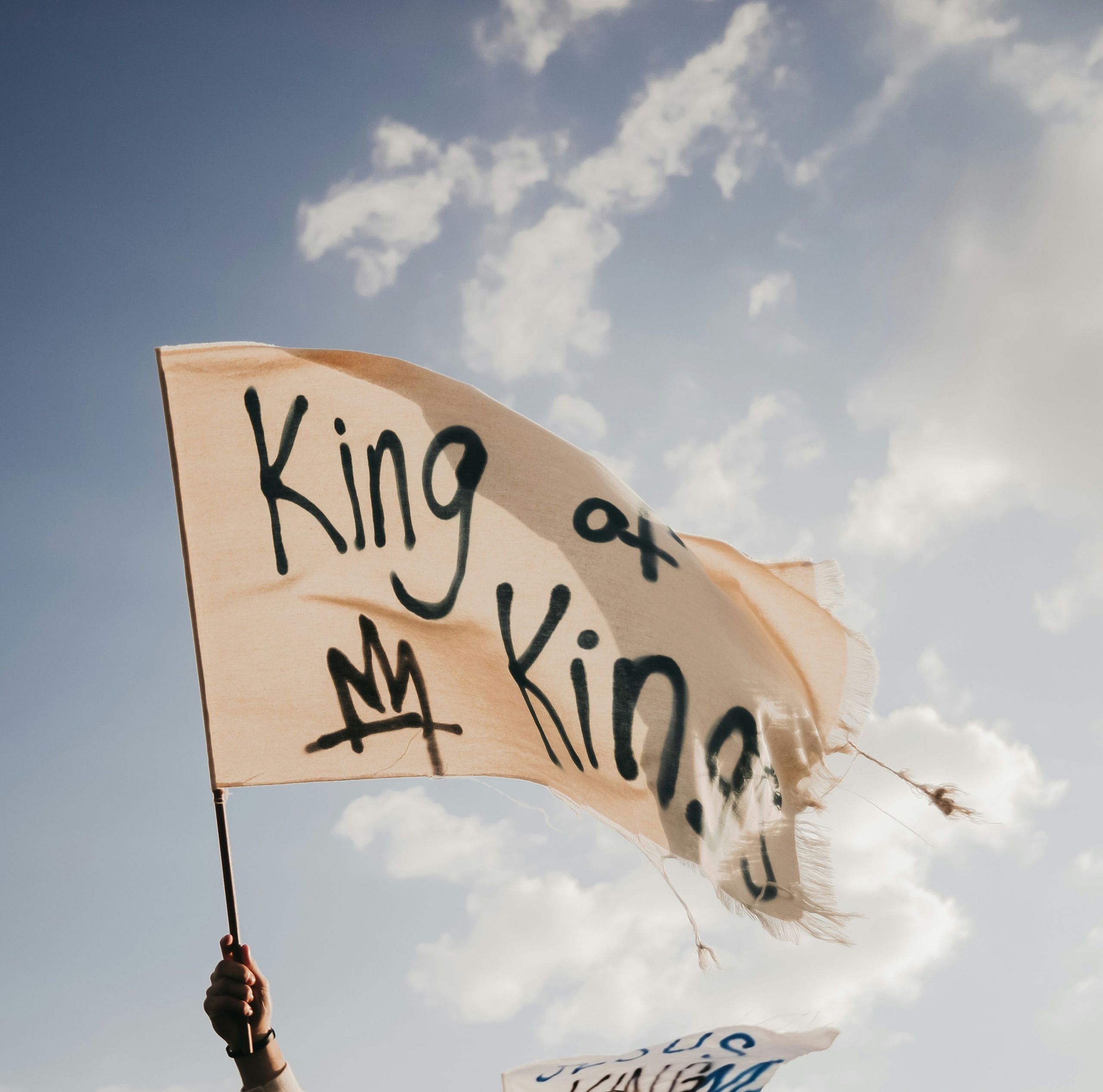 Handbemalte King-of-Kings-Fahne vor blauem Himmel