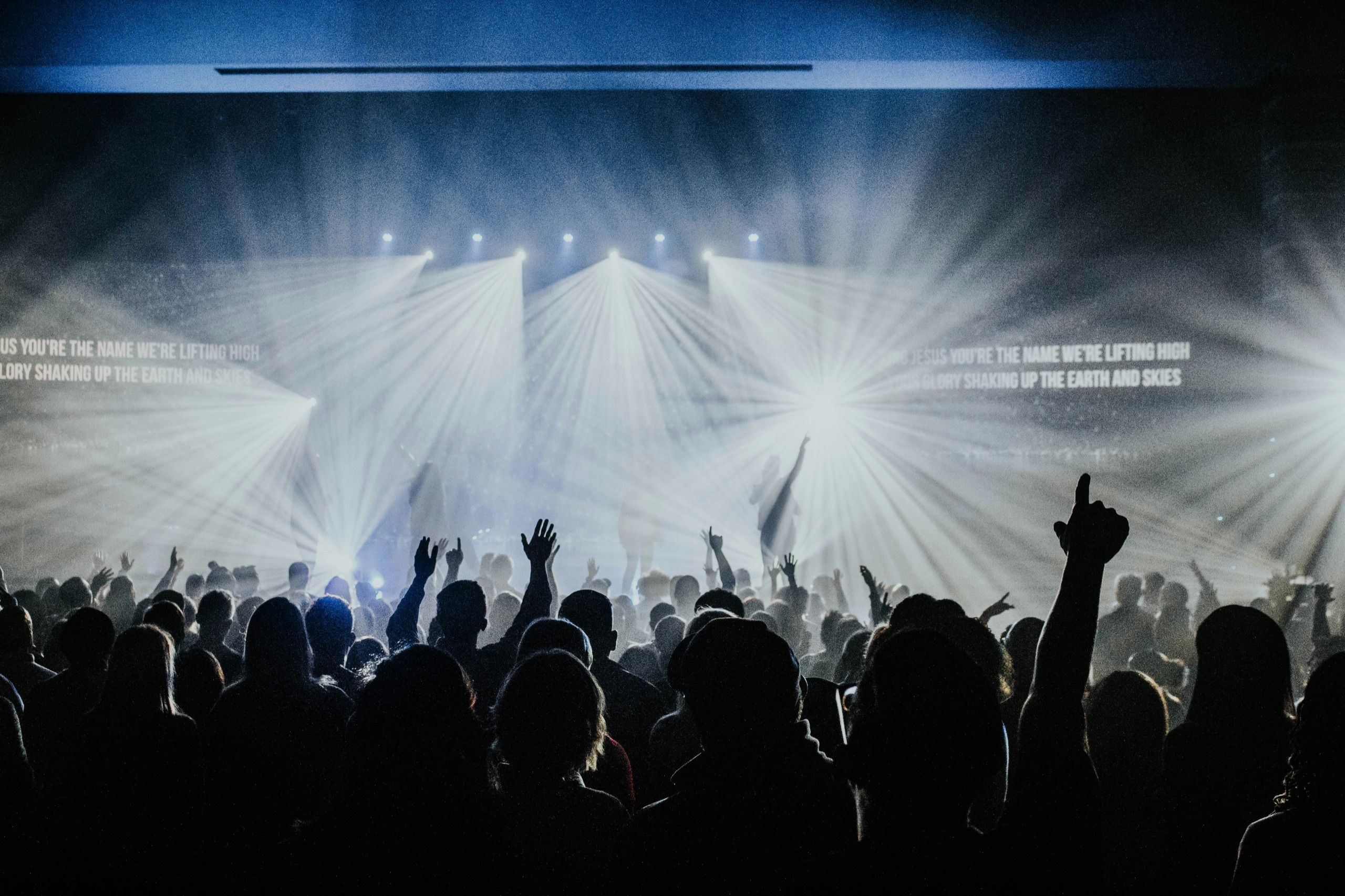 Große Worship-Nacht mit Lichtstrahlen und erhobenen Händen