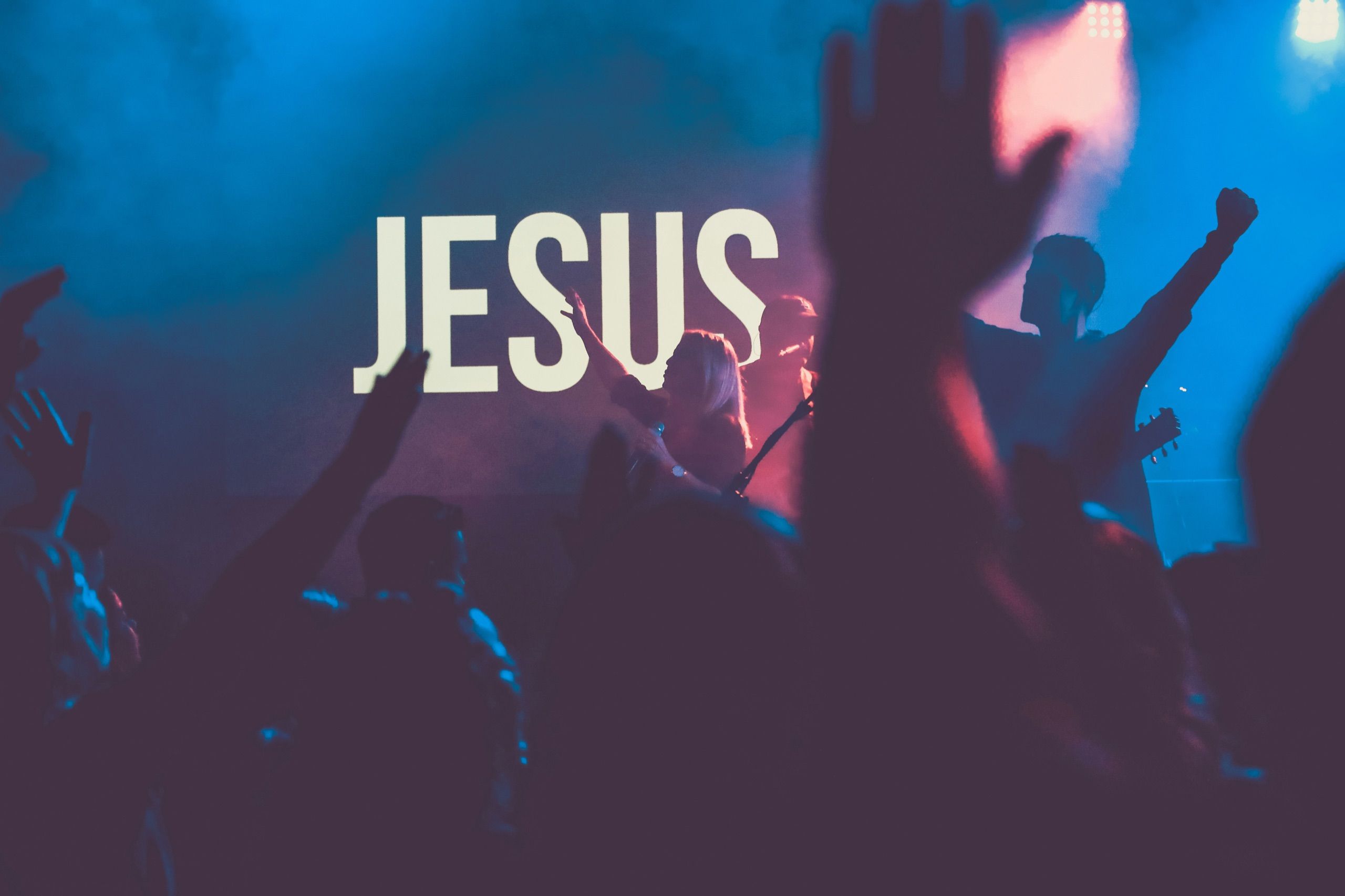 Große Worship-Nacht mit Lichtstrahlen und erhobenen Händen